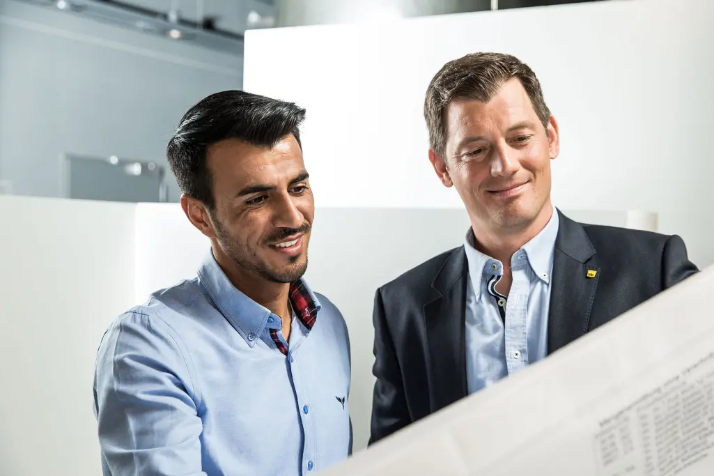 Konsultacija između zaposlenog kompanije Sto i klijenta, gledaju građevinski plan.