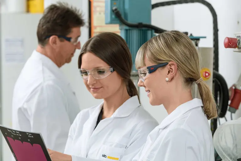 Dve koleginice iz kompanije Sto iz sektora za istraživanje i razvoj gledaju laboratorijski izveštaj, u pozadini još jedan zaposleni iz sektora I&R; izvor slike: © Martin Baitinger, Böblingen, Nemačka.