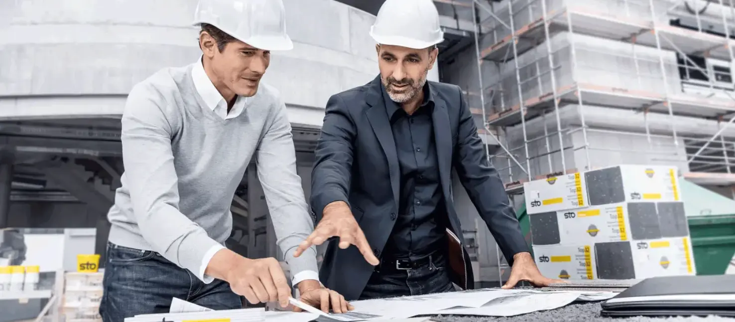 Inženjeri s kacigama pregledaju planove — planiranje, tender, savetovanje.